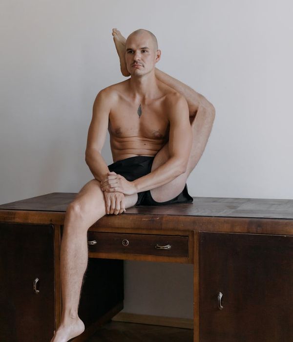 Man performing a controlled strength exercise in a minimalist studio.